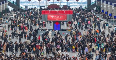 People line up to board trains at Zhengzhou, in central Henan province, China, Jan. 26, 2024. (AFP Photo)