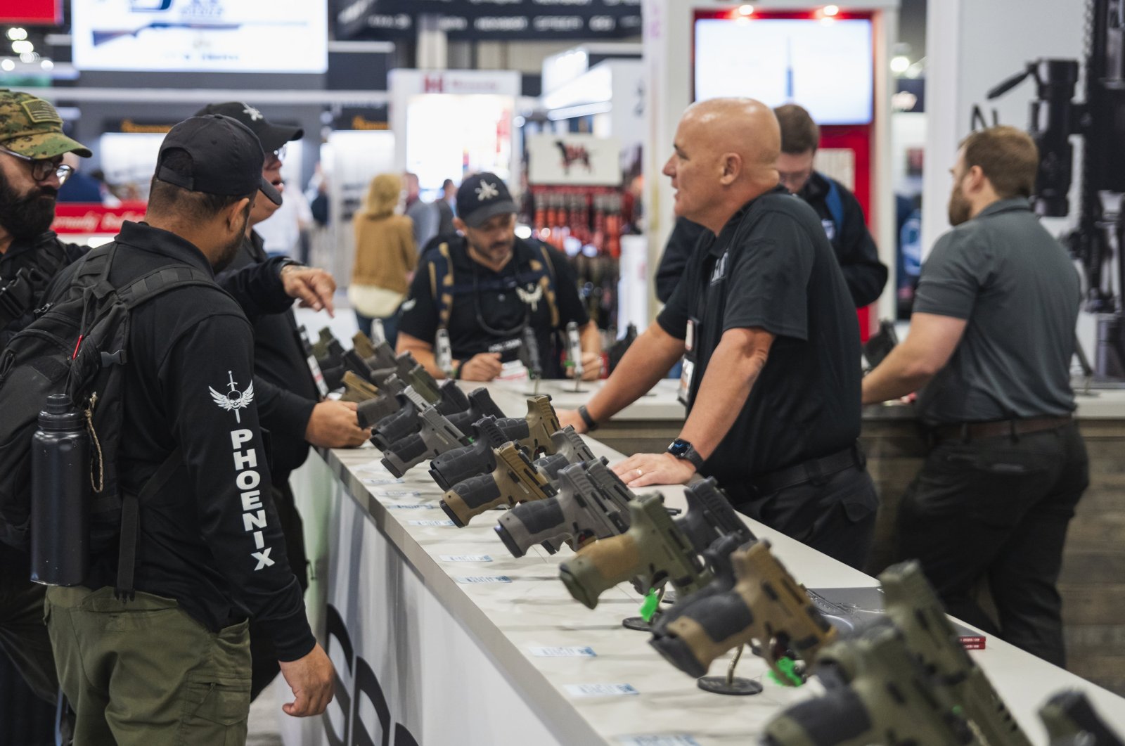 Visitors examine firearms produced by one of the Turkish leading manufacturers, Sarsılmaz, displayed during an expo held in Las Vegas, U.S., Jan. 26, 2024. (AA Photo)