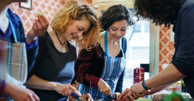 Participants of a cooking class enjoy cutting vegetables. (Getty Images Photo)
