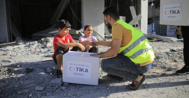 A volunteer is seen delivering humanitarian aid provided by the Turkish Cooperation and Coordination Agency (TIKA) in an undisclosed location on Jan. 6, 2024. (AA Photo)