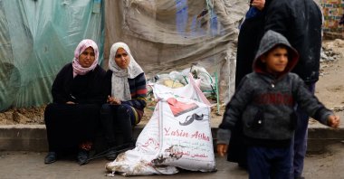 Palestinian women sit near bags of flour distributed by the United Nations Relief and Works Agency for Palestine Refugees in the Near East (UNRWA) amid the Israel-Palestine conflict, Rafah, Gaza Strip, Palestine, Jan. 29, 2024. (Reuters Photo)