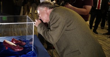 Rhys Thomas, author of &quot;The Ruby Slippers of Oz,&quot; takes a photo of a pair of ruby slippers once worn by Judy Garland in &quot;The Wizard of Oz,&quot; Brooklyn Center, Minnesota, U.S., Sept. 4, 2018. (AP Photo)