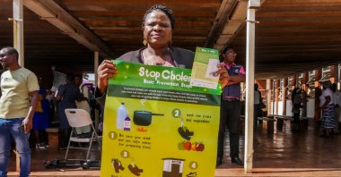 A woman displays a poster informing against cholera during the launch of a cholera vaccination program at the Kuwadzana Polyclinic, Harare, Zimbabwe, Jan. 29, 2024. (EPA Photo)