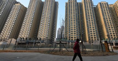 A woman walks past an Evergrande Group residential complex called Evergrande Palace in Beijing, China, Jan. 29, 2024. (AFP Photo)