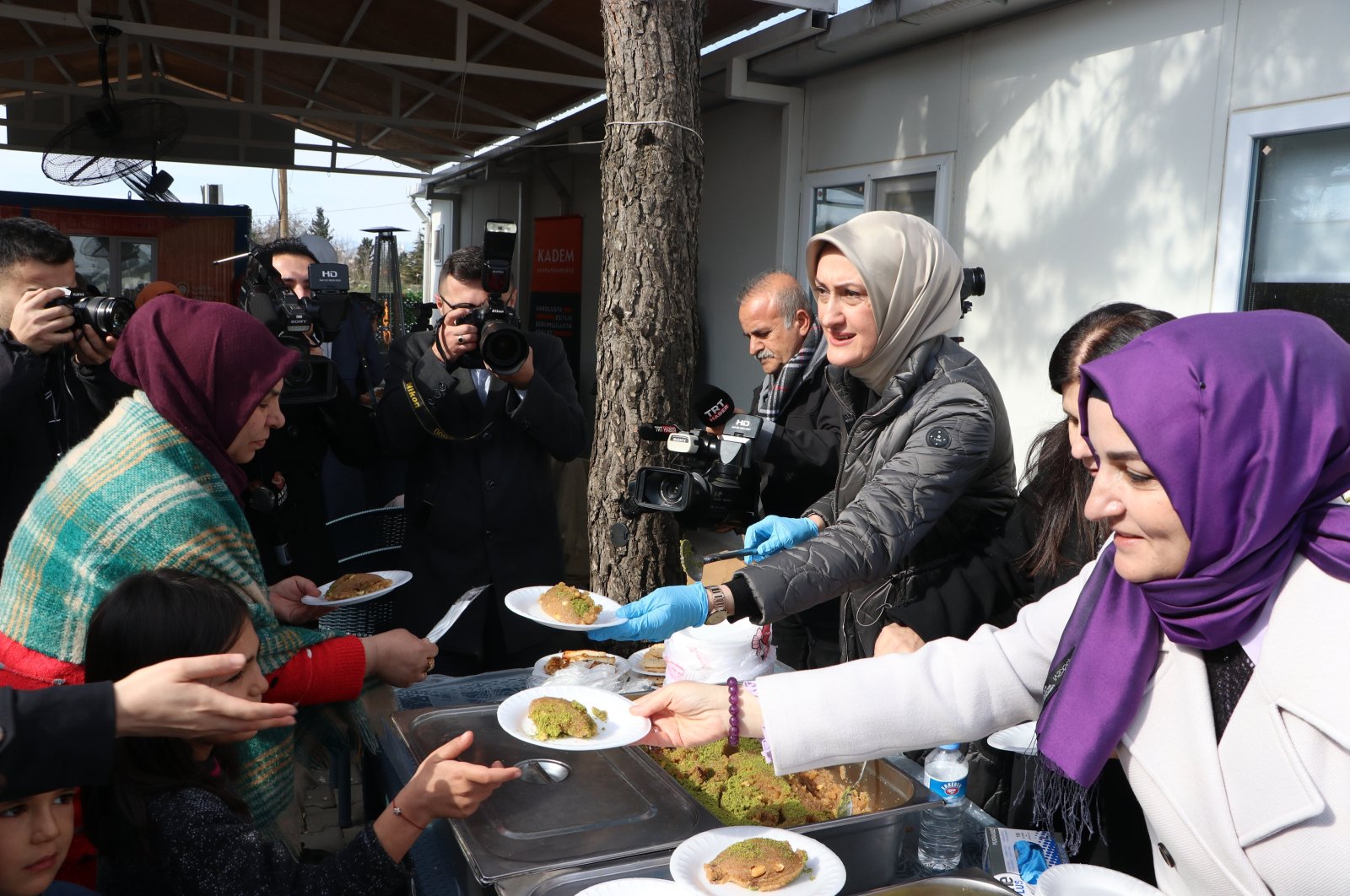 Türkiye&#039;s Women and Democracy Foundation (KADEM) Chairperson Saliha Okur Gümrükçüoğlu (R) serves a sweet dish for earthquake victims in a container city, Kahramanmaraş, Türkiye, Jan. 30, 2024. (AA Photo)