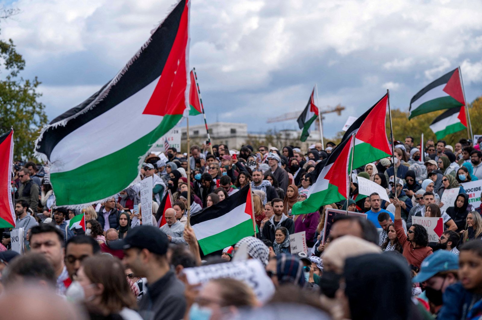 People raise flags and posters during a rally held by American Muslims for Palestine calling for a cease-fire in Gaza near the Washington Monument, Washington, U.S., Oct. 21, 2023. (Reuters Photo)