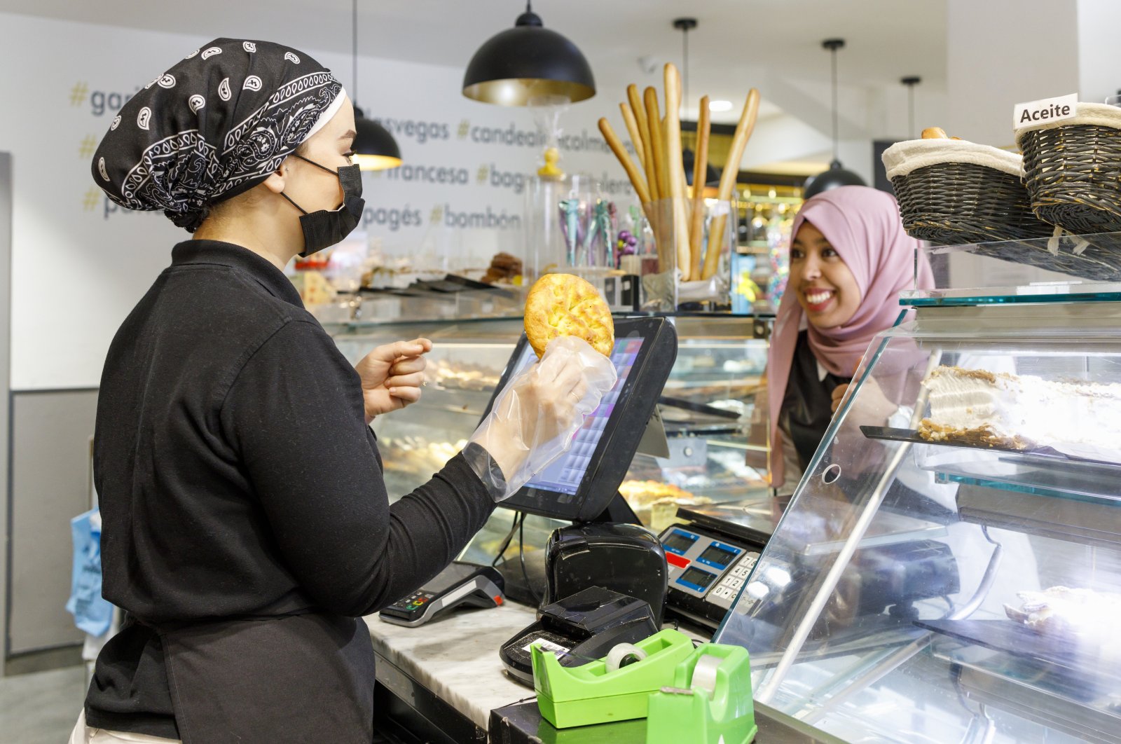 A smiling woman wearing a Muslim headscarf (hijab) buying food from a bakery at an unspecified location in this undated file photo. (Getty Images, File Photo)