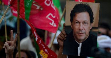 An activist of the Pakistan Tehreek-e-Insaf (PTI) holds a portrait of former Prime Minister Imran Khan at a rally in Karachi, Pakistan, Oct. 28, 2022. (AFP Photo)