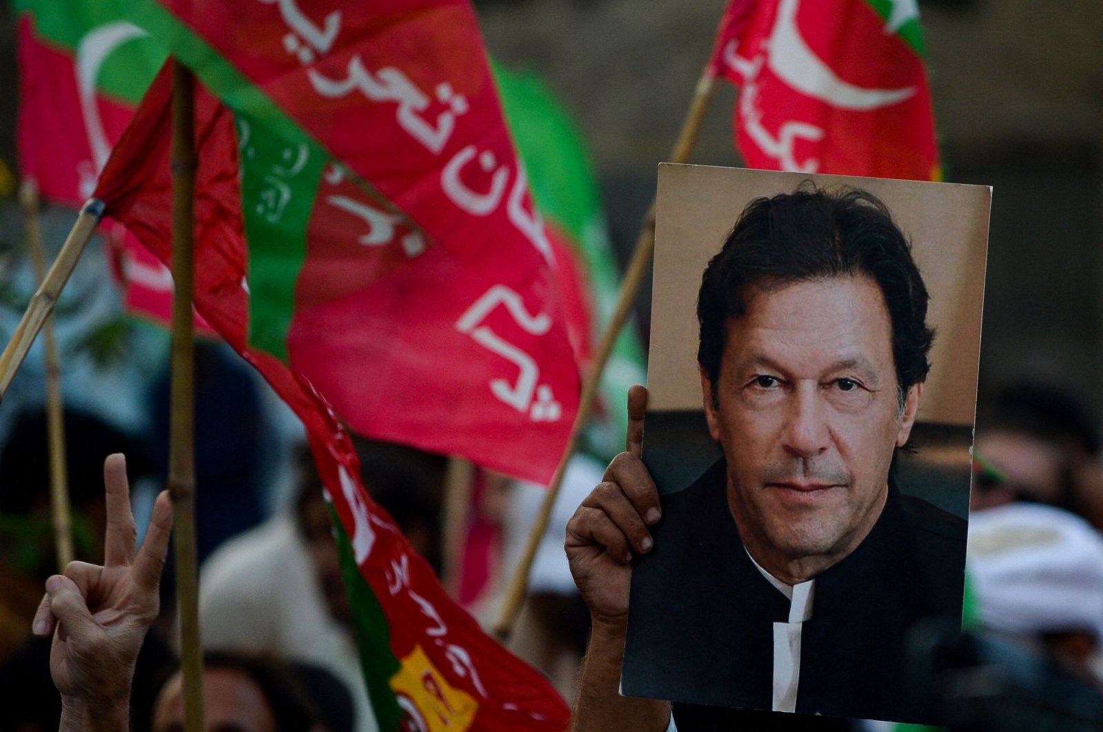 An activist of the Pakistan Tehreek-e-Insaf (PTI) holds a portrait of former Prime Minister Imran Khan at a rally in Karachi, Pakistan, Oct. 28, 2022. (AFP Photo)