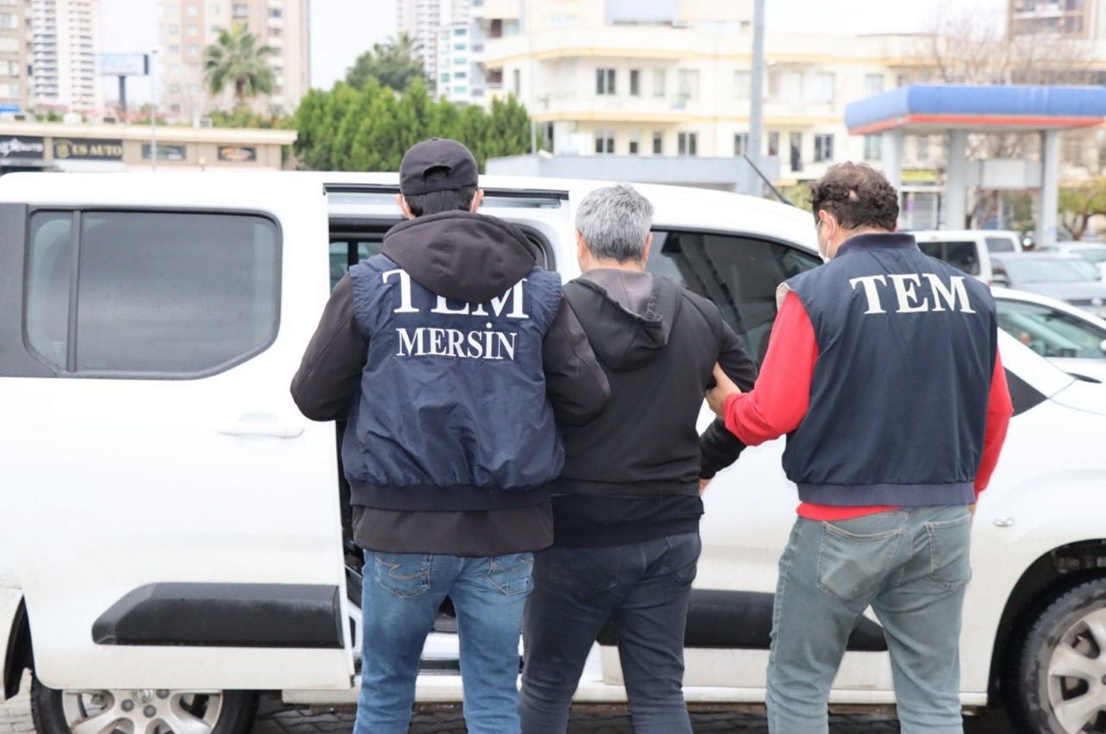 Two officers escort a former police chief wanted for being a FETÖ member and avoiding an eight-year sentence in southern Mersin province, Türkiye, Feb. 1, 2024. (AA Photo)