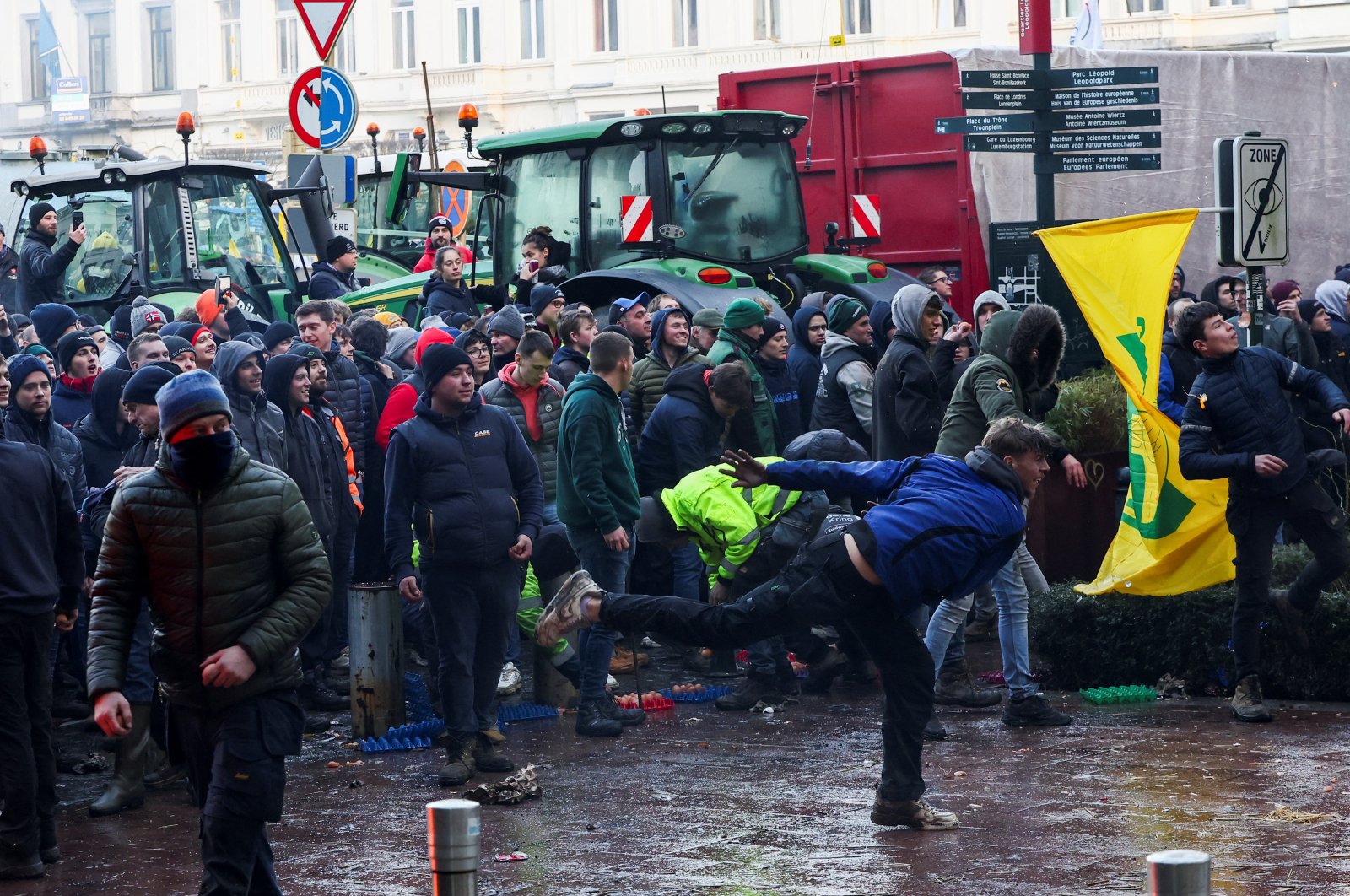 A person throws eggs toward the police officers as Belgian farmers use their tractors to block the European Union headquarters, protesting price pressure, taxes and green regulation, on the day of the EU summit in Brussels, Belgium, Feb. 1, 2024. (Reuters Photo)