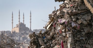 A collapsed building with Abdulhamid Han Mosque in the background after a powerful earthquake in Kahramanmaraş, Türkiye, Feb. 18, 2023. (EPA Photo)