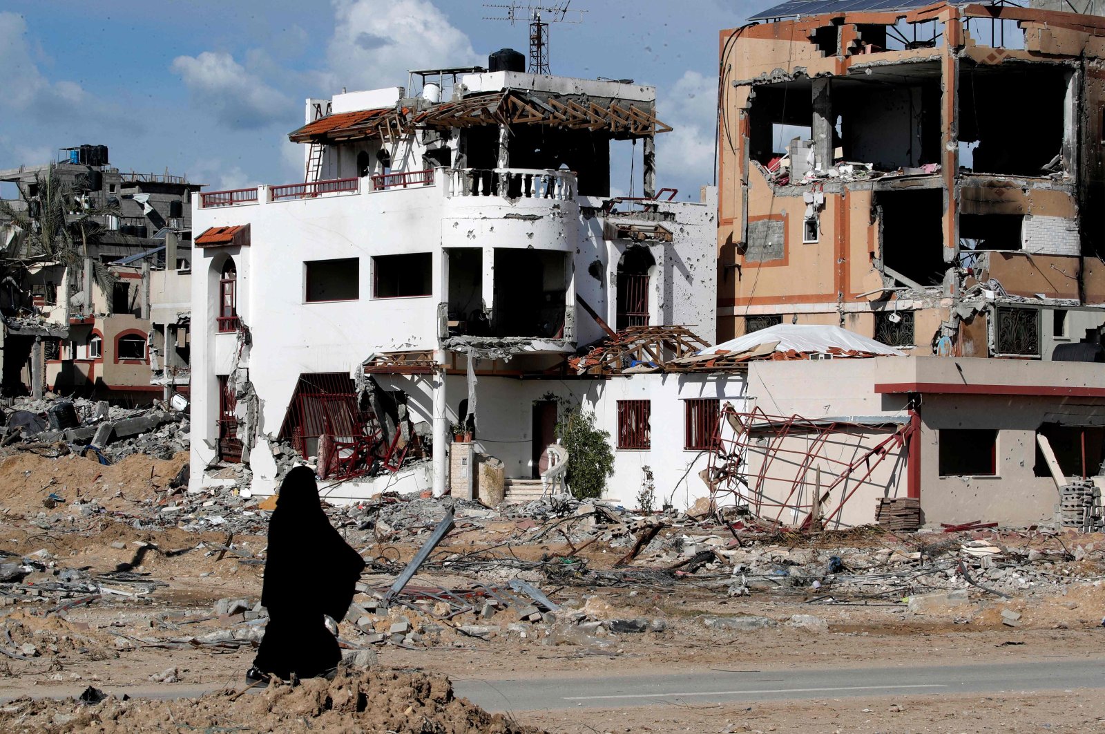 A woman walks past a destroyed building in the Maghazi camp for Palestinian refugees, which was severely damaged by Israeli bombardment in the central Gaza Strip, Palestine, Feb. 1, 2024. (AFP Photo)
