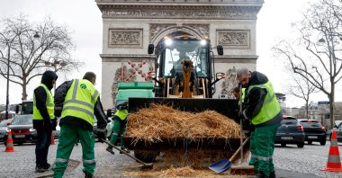 Municipal workers sweep up straw during a protest by farmers over price pressures, taxes and green regulation, grievances shared by farmers across Europe, Paris, France, Feb. 1, 2024. (Reuters Photo)