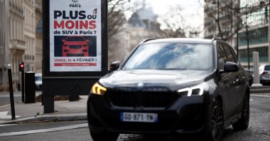 A poster reading &quot;More or less SUVs in Paris? Vote on February 4&quot; is seen on a billboard in a street as Paris City Hall is set to organize a public vote on SUVs in the city, Paris, France, Feb. 2, 2024. (Reuters Photo)