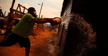 A man douses a forest fire in the hills in Quilpe comune, Valparaiso region, Chile, Feb. 3, 2024. (AFP Photo)