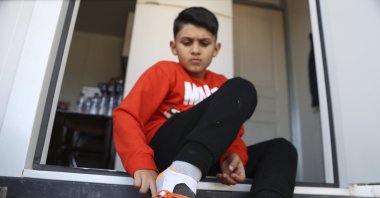 Southeastern Türkiye earthquake survivor Semih Ege Inci puts on his football cleats for training, Gaziantep, Türkiye, Feb. 5, 2024. (AA Photo)