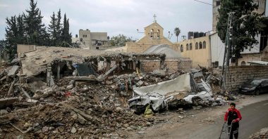 A young boy walks in front of Gaza City&amp;#039;s Greek Orthodox Church of Saint Porphyrius, which was damaged in Israeli bombardment on Jan. 5, 2024. (AFP File Photo)