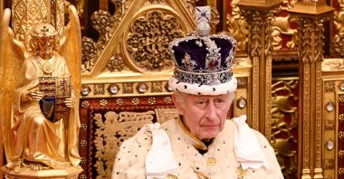 Britain's King Charles III, wearing the Imperial State Crown and the Robe of State, sits on The Sovereign's Throne in the House of Lords chamber, during the State Opening of Parliament, at the Houses of Parliament, in London, on Nov. 7, 2023. (AFP Photo)
