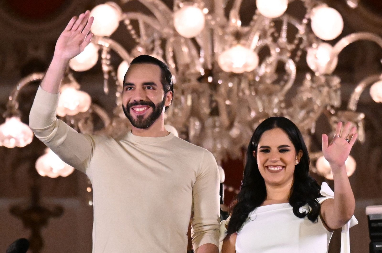 TOPSHOT - Salvadoran President Nayib Bukele greets supporters next to his wife Gabriela Rodriguez after the presidential and legislative elections in San Salvador on February 4, 2024. Fireworks erupted in El Salvador's capital as gang-busting President Nayib Bukele claimed to have won reelection with more than 85 percent of votes cast: "a record in the entire democratic history of the world." (Photo by Marvin RECINOS / AFP)