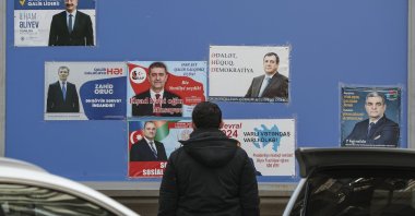 An Azerbaijani man looks at pre-electoral posters of candidates for the upcoming extraordinary presidential elections, Baku, Azerbaijan, Feb. 5, 2024. (EPA Photo)