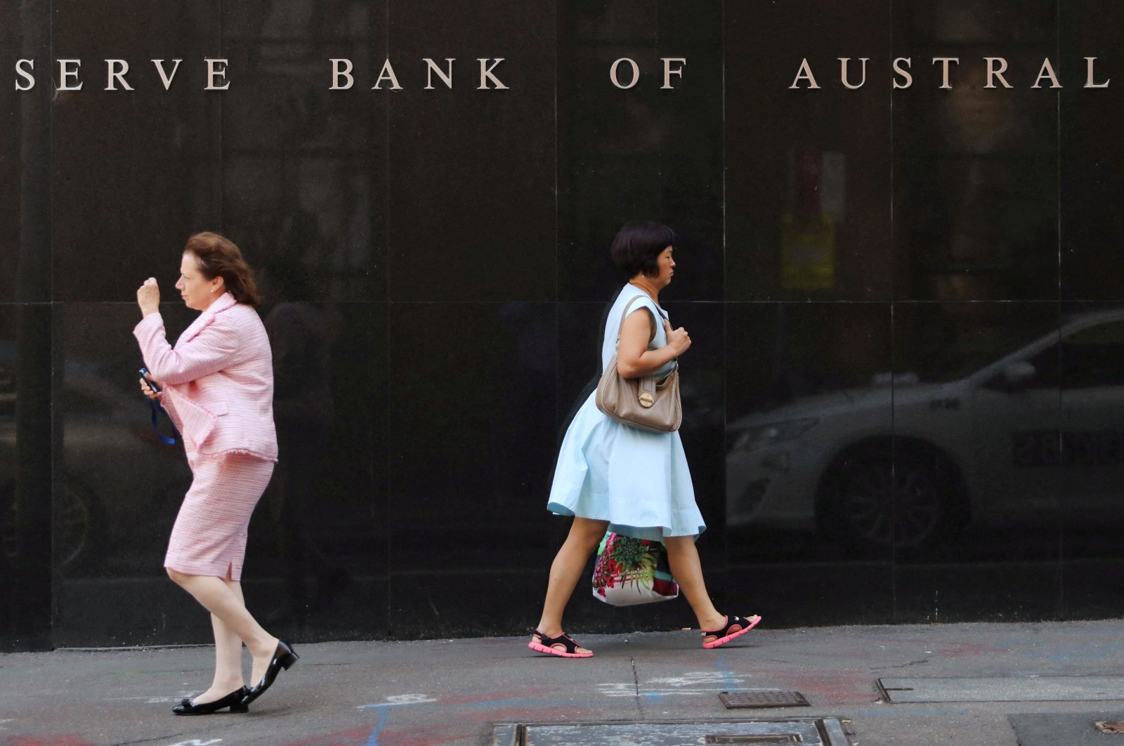 Two women walk next to the Reserve Bank of Australia headquarters in central Sydney, Australia, Feb. 6, 2018. (Reuters Photo)