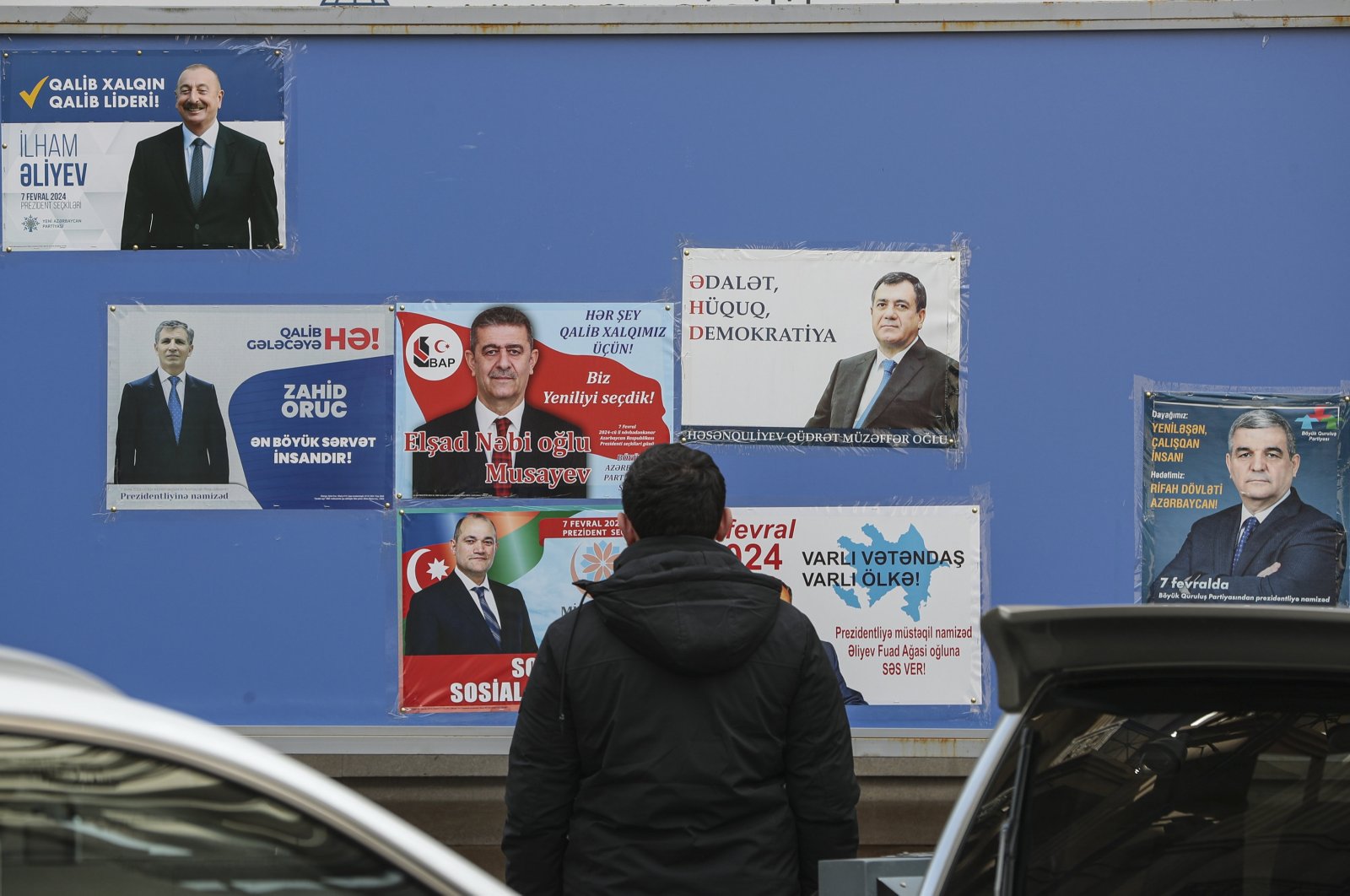 An Azerbaijani man looks at pre-electoral posters of candidates for the upcoming extraordinary presidential elections, Baku, Azerbaijan, Feb. 5, 2024. (EPA Photo)