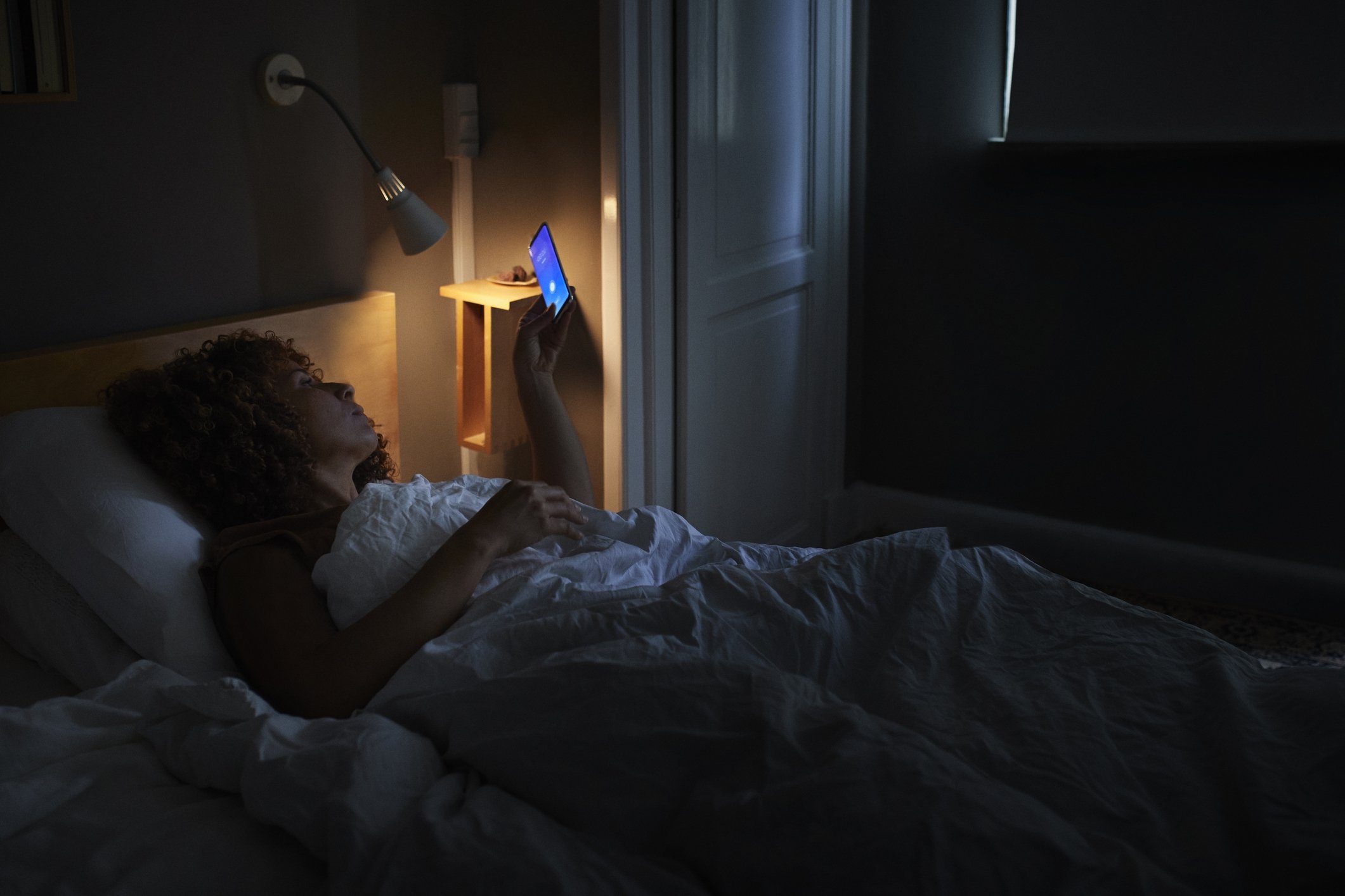 Limiting screen time before bedtime is crucial as the blue light from screens disrupts melatonin production, making it harder to fall asleep at the appropriate time. (Getty Images Photo)