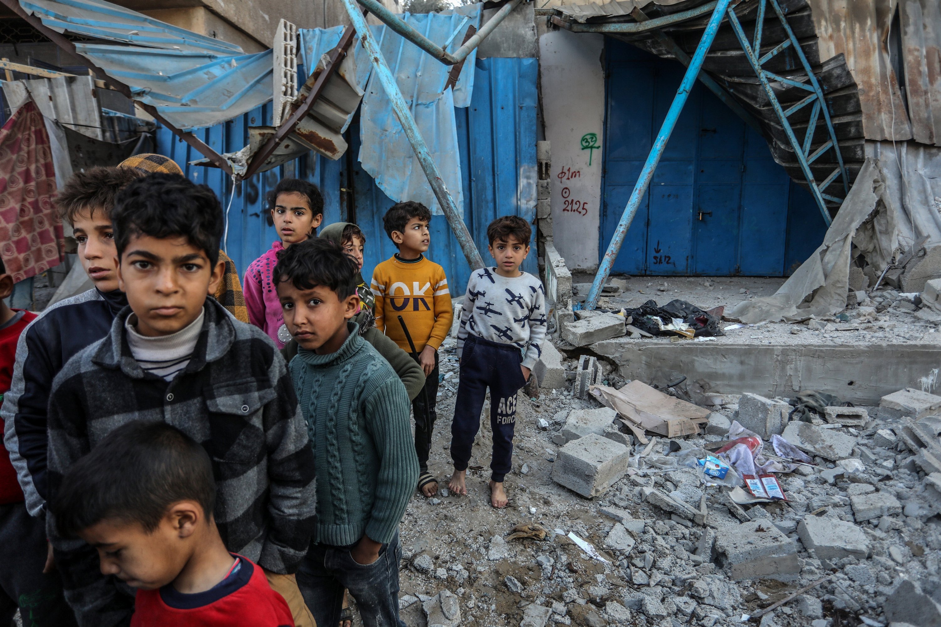 Gazan children wait amid rubbles of buildings destroyed in Israeli attacks on Rafah, Gaza, Feb. 7, 2024. (AA Photo)