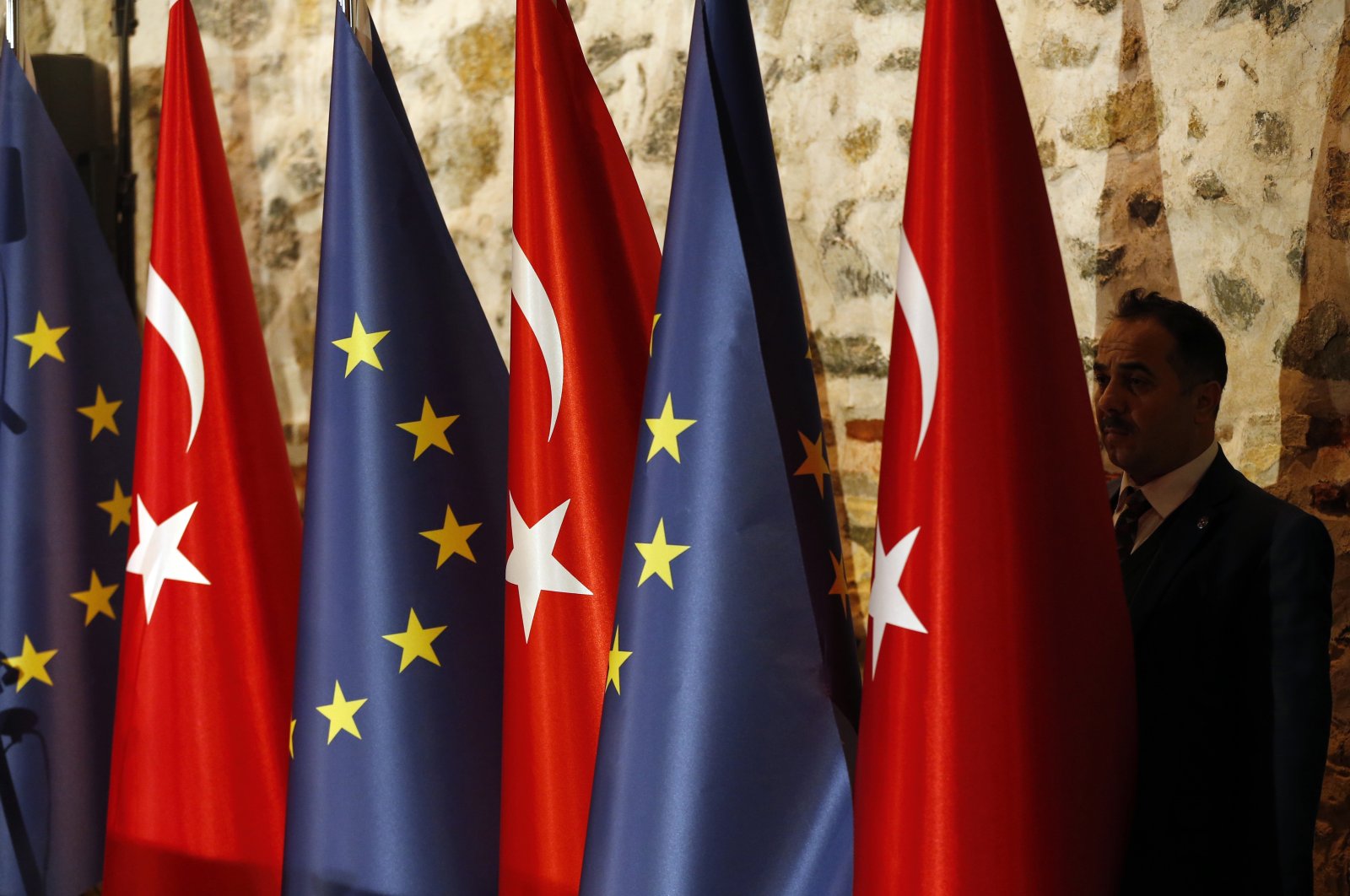 An official adjusts Türkiye&#039;s and European flags prior to the opening session of a high-level meeting between EU and Turkish officials, Istanbul, Türkiye, Feb. 28, 2019. (AP Photo)