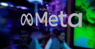 People are seen behind a logo of Meta Platforms, during a conference in Mumbai, India, Sept. 20, 2023. (Reuters Photo)