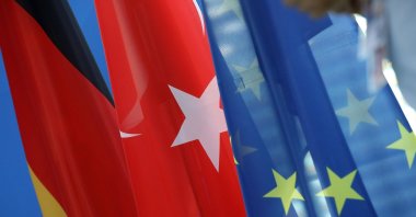 The German (L) and Turkish (C) national flags hang beside a European Union flag during a news conference with then-German Chancellor Angela Merkel and President Recep Tayyip Erdoğan, at the Chancellery in Berlin, Germany, Sept. 28, 2018. (Getty Images Photo)