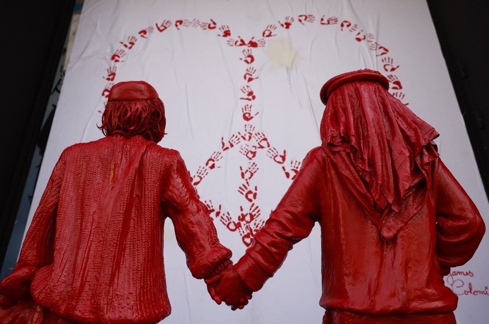 A sculpture by French urban artist James Colomina of an Israeli and a Palestinian boy holding hands in front of a heart with the symbol of peace is on display in a street in Barcelona, Spain, Feb. 8, 2024. (EPA Photo)