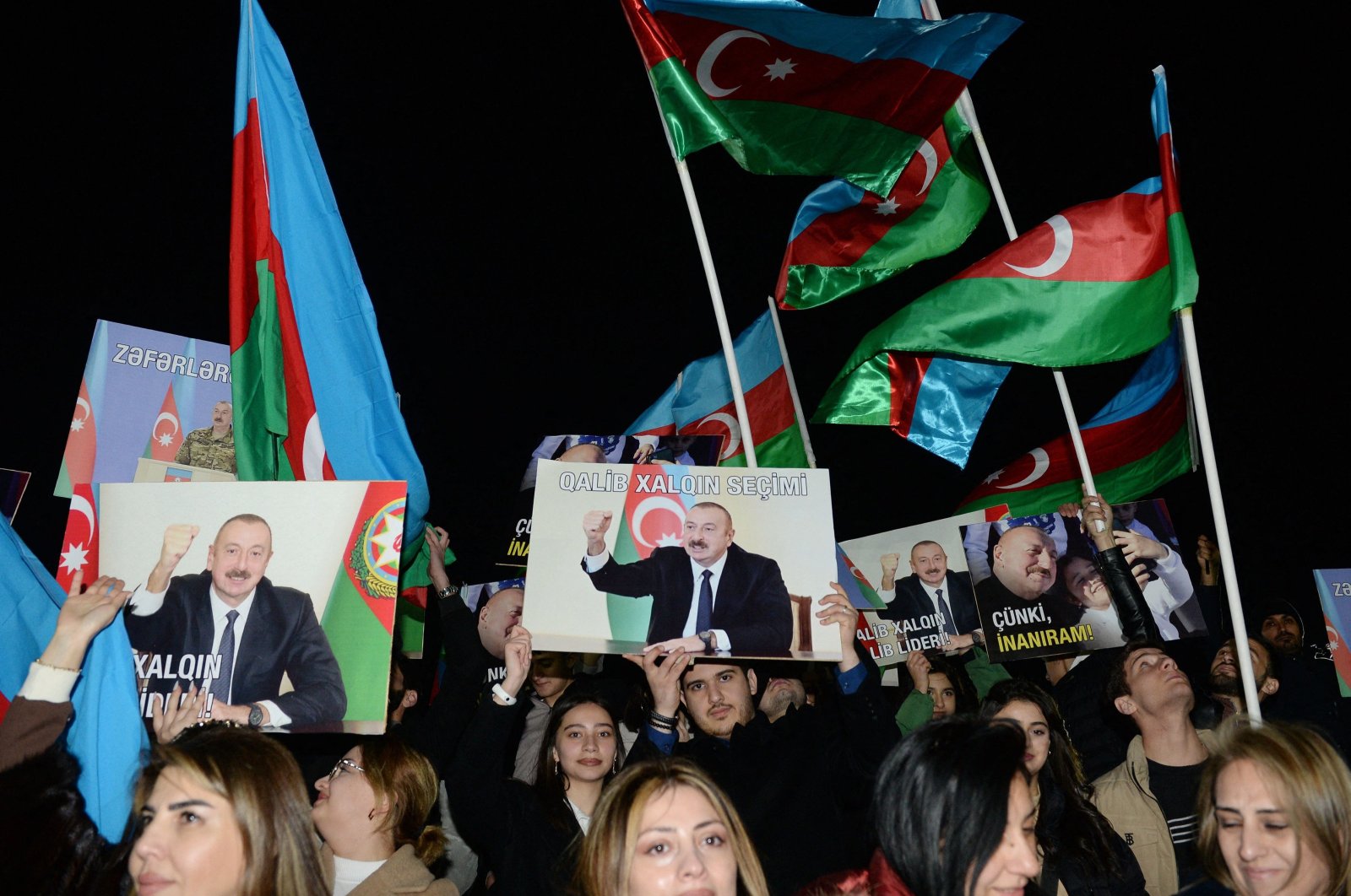 Supporters of Azeri President and presidential candidate Ilham Aliyev rally with national flags and his portraits after polls closed in snap presidential election, Baku, Azerbaijan, Feb. 7, 2024. (AFP Photo)