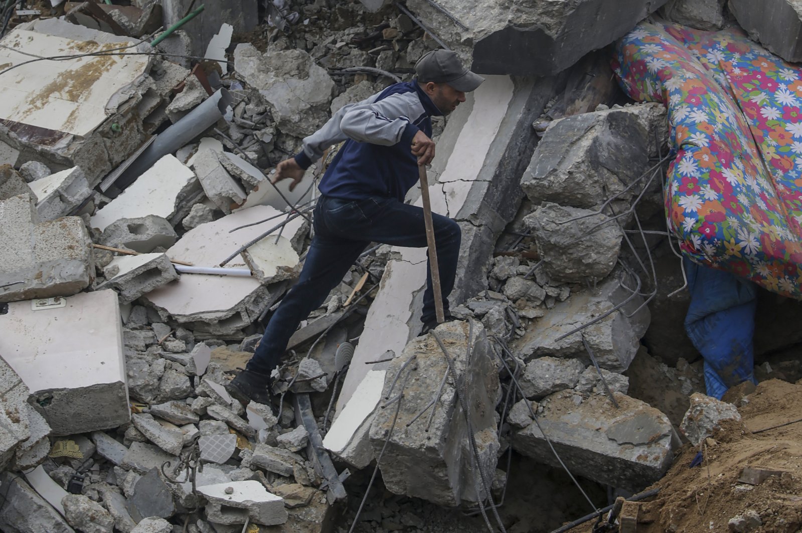 A Palestinian man searches for bodies and survivors among the rubble of a house destroyed in an Israeli airstrike, Deir Al Balah, Gaza, Palestine, Feb. 2024. (EPA Photo)