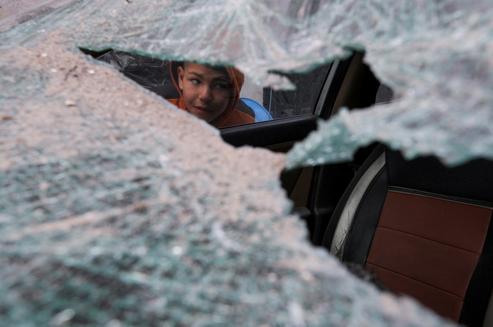 A Palestinian child inspects a damaged vehicle at the site of an Israeli strike, in Rafah, southern Gaza Strip, Palestine, Feb. 9, 2024. (Reuters Photo)