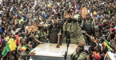 An unidentified representative of the junta waves from a military vehicle as Malians supporting the overthrow of President Ibrahim Boubacar Keita gathers to celebrate in the capital Bamako, Mali, Aug. 21, 2020. (AP File Photo)