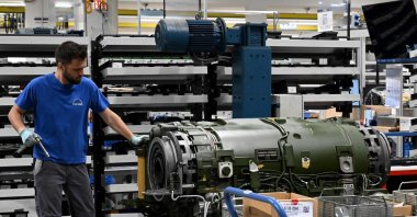 An employee works on a tank gearbox in an assembly hall of the German gear manufacturing company Renk, Augsburg, Germany, May 8, 2023. (AFP Photo)