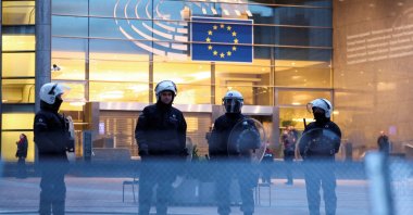 Police officers in riot gear stand guard in front of the European Parliament as farmers from Belgium and other European countries protest over price pressures, taxes and green regulation, in Brussels, Belgium, Feb. 1, 2024. (Reuters Photo)