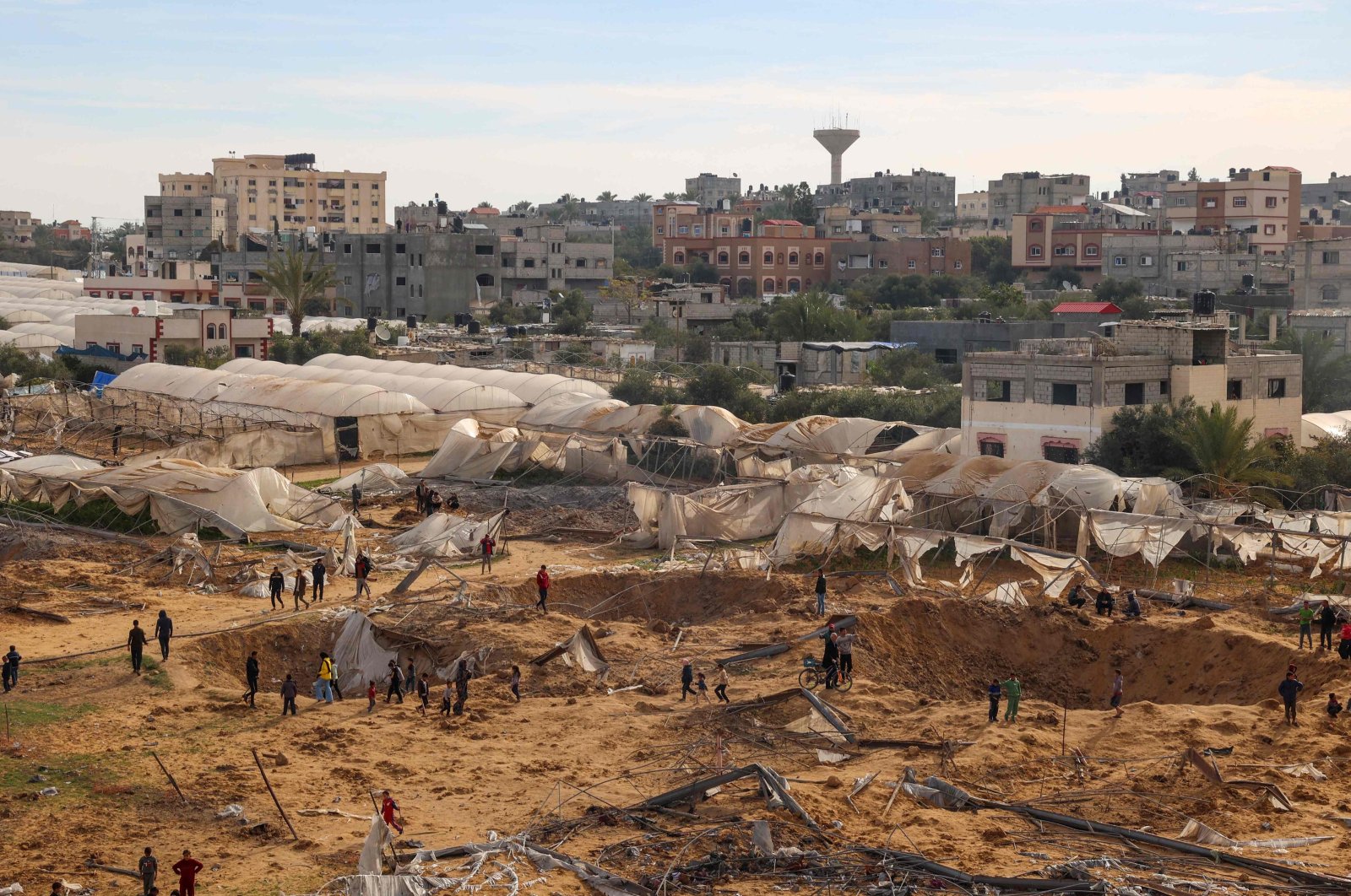 People stand around craters caused by Israeli bombardment in Rafah, southern Gaza Strip, Palestine, Feb. 12, 2024. (AFP Photo)