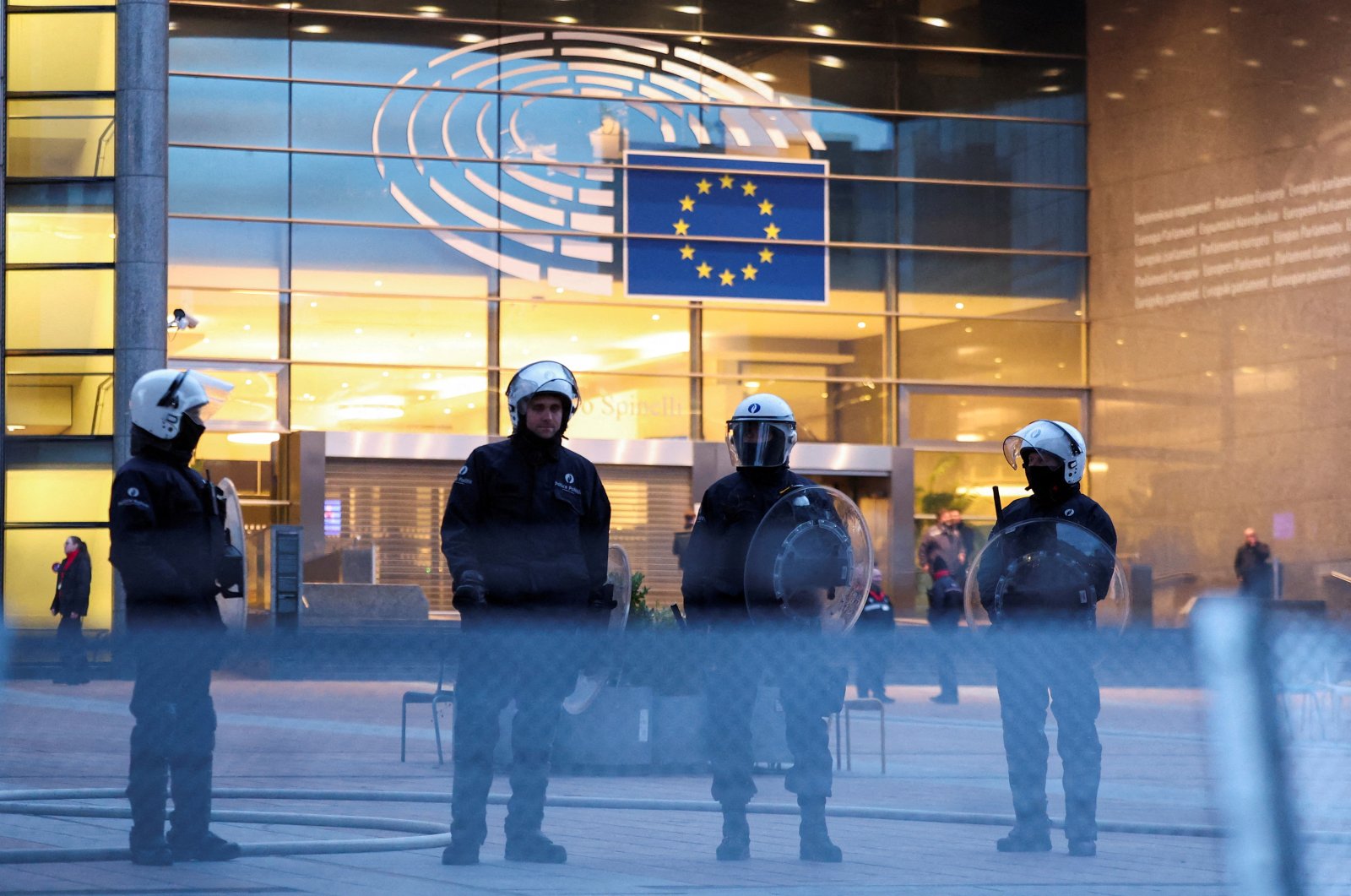 Police officers in riot gear stand guard in front of the European Parliament as farmers from Belgium and other European countries protest over price pressures, taxes and green regulation, in Brussels, Belgium, Feb. 1, 2024. (Reuters Photo)