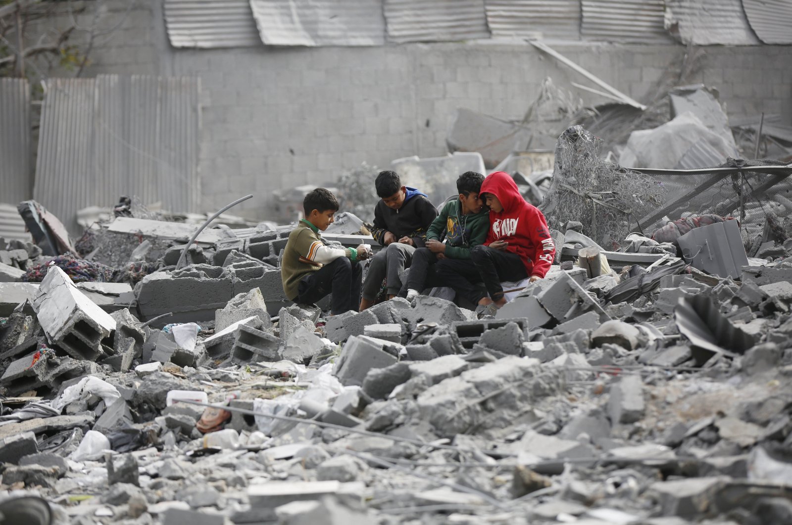 Palestinian children sit among the rubble of a building destroyed in Israeli attacks on Gaza, Palestine, Feb. 13, 2024. (AA Photo)