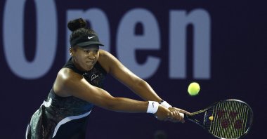 Japan's Naomi Osaka in action in the round of 32 match against Croatia's Petra Martic during their women's singles tennis match at the Qatar WTA Open at Khalifa International Tennis and Squash Complex, Doha, Qatar, Feb. 13, 2024. (AFP Photo)