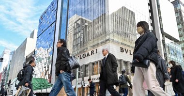 Pedestrians cross the street in front of luxury shops at the Ginza shopping district in Tokyo, Japan, Jan. 19, 2024. (AFP Photo)