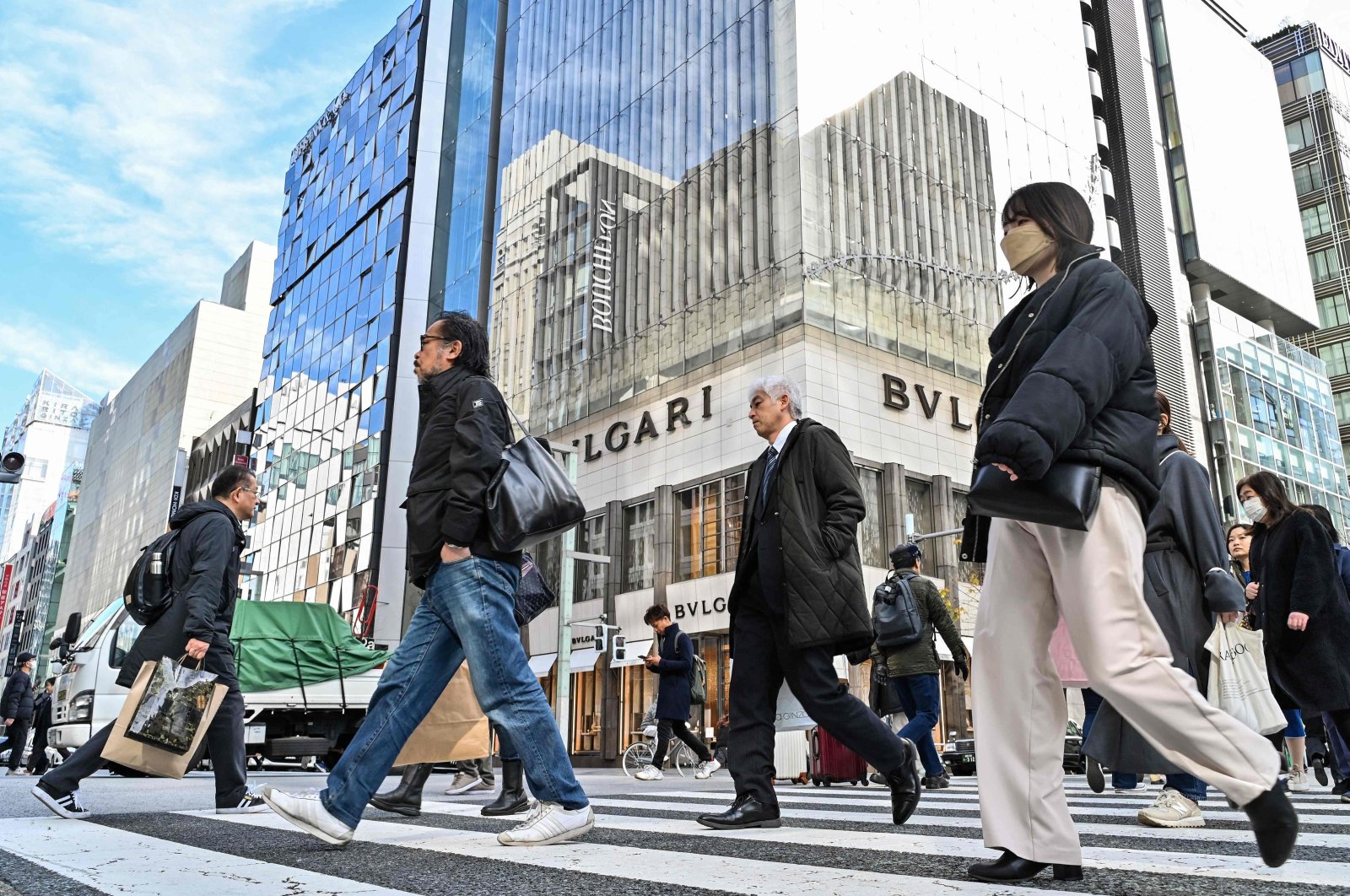 Pedestrians cross the street in front of luxury shops at the Ginza shopping district in Tokyo, Japan, Jan. 19, 2024. (AFP Photo)