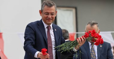 Main opposition Republican People's Party Chairperson Özgür Özel hands out flowers during a meeting at Cumhuriyet Square in the Bergama district of Izmir, Türkiye, Feb. 16, 2024. (AA Photo)