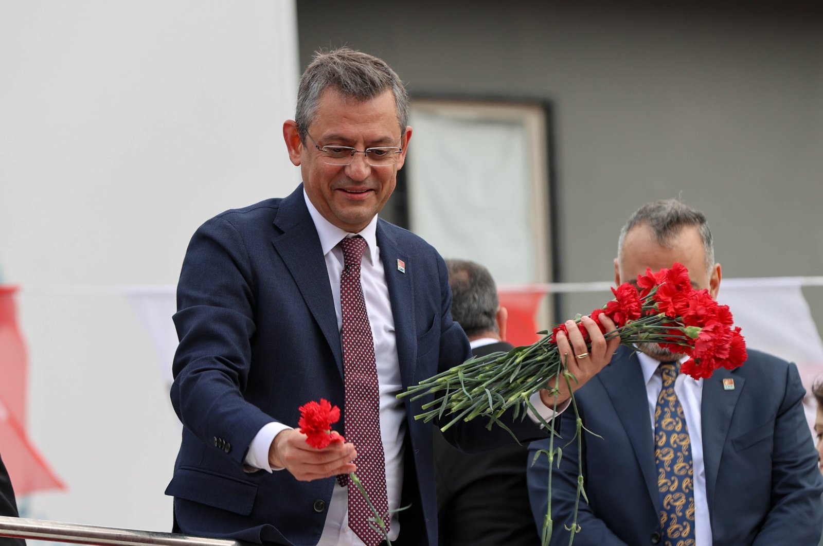 Main opposition Republican People&#039;s Party Chairperson Özgür Özel hands out flowers during a meeting at Cumhuriyet Square in the Bergama district of Izmir, Türkiye, Feb. 16, 2024. (AA Photo)