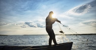 A fisherman reels in a catch on his boat, Çivril, Denizli, Türkiye, Feb. 19, 2024. (Getty Images)