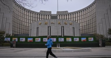 A woman jogs past the People's Bank of China, Beijing, China, Feb. 20, 2024. (AP Photo)