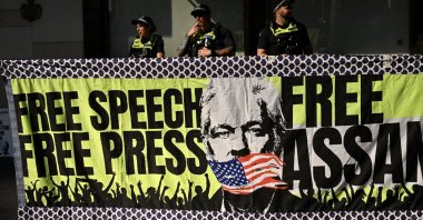 Victorian Police officers stand behind a banner at a 24-hour vigil for Julian Assange in Melbourne, Australia, Feb. 20, 2024. (EPA Photo)